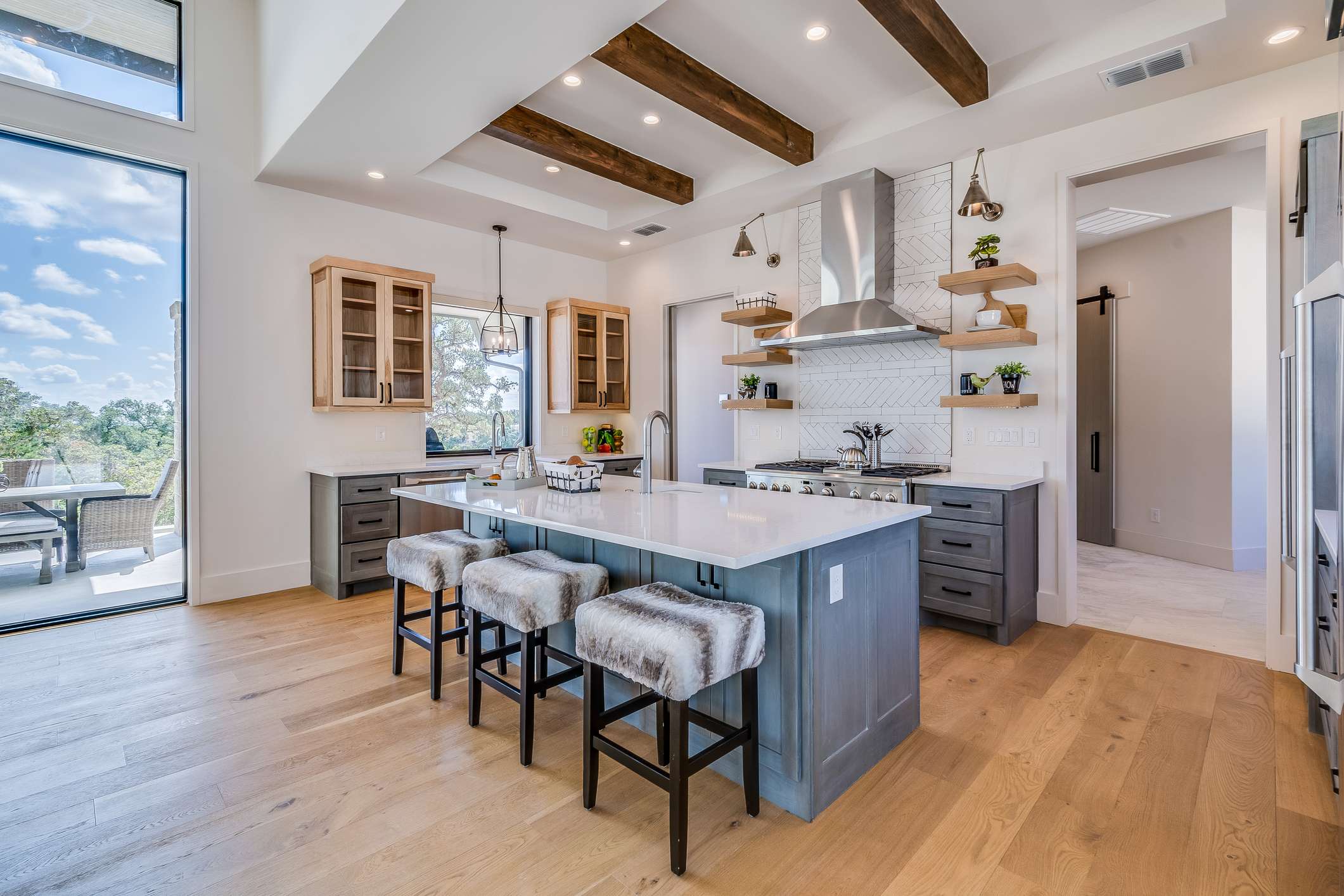 Natural wood flooring and gray blue cabinetry in new home